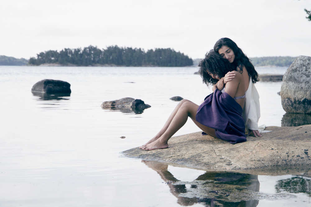 Zwei junge Frauen sitzen am Ufer eines Sees. Sie tragen nachhaltige Kimonos